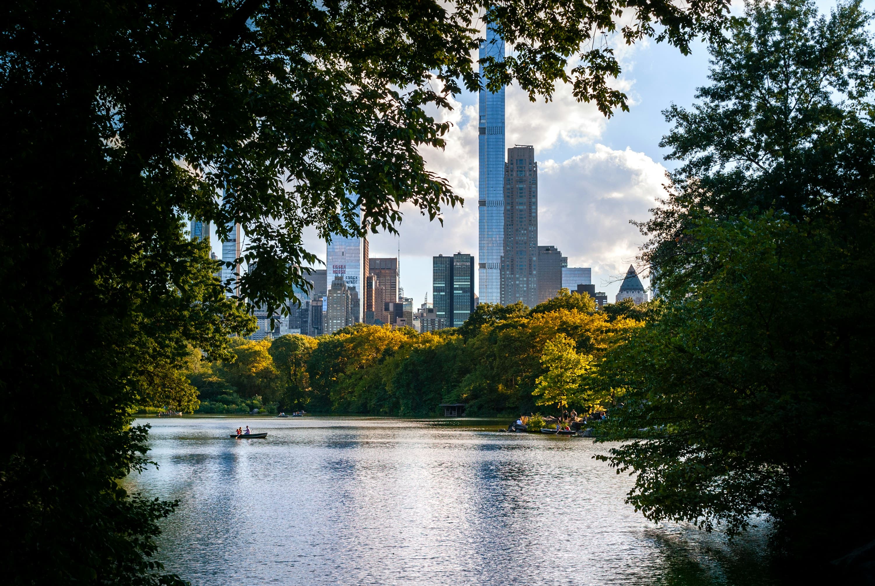 The Manhattan skyline seen across the lake in Central Park, framed by trees